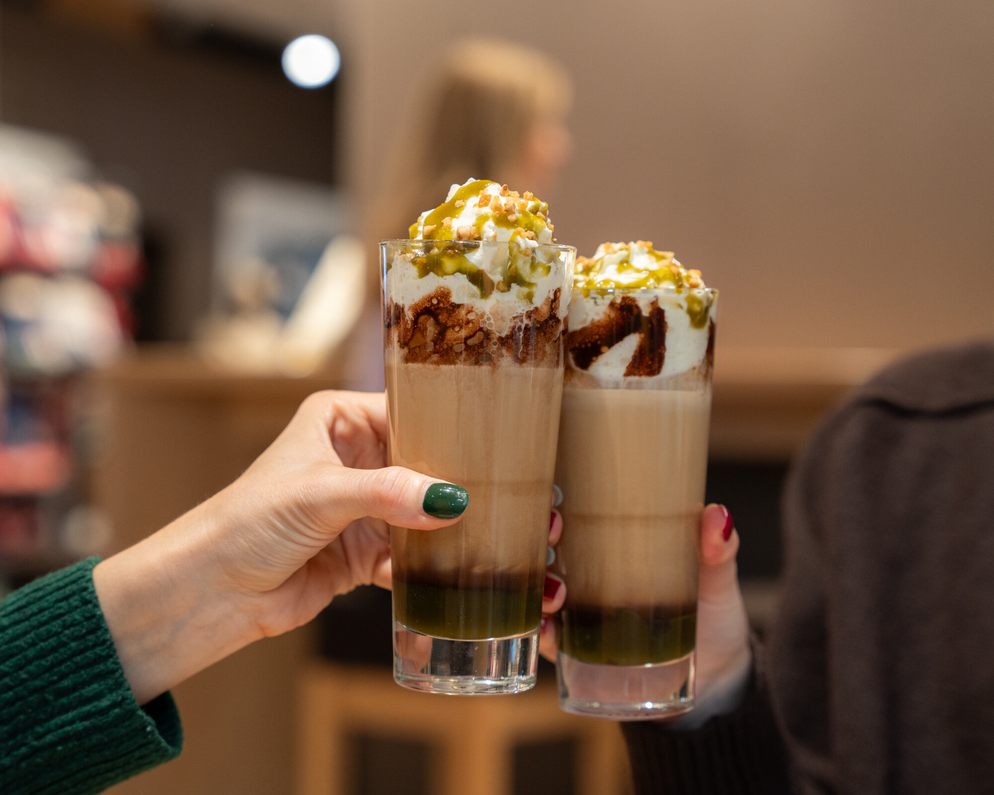 Zwei Eiskaffees mit Sahne werden angestoßen