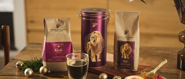 Kaffeepackungen und Dose mit Löwenmotiv auf Tisch