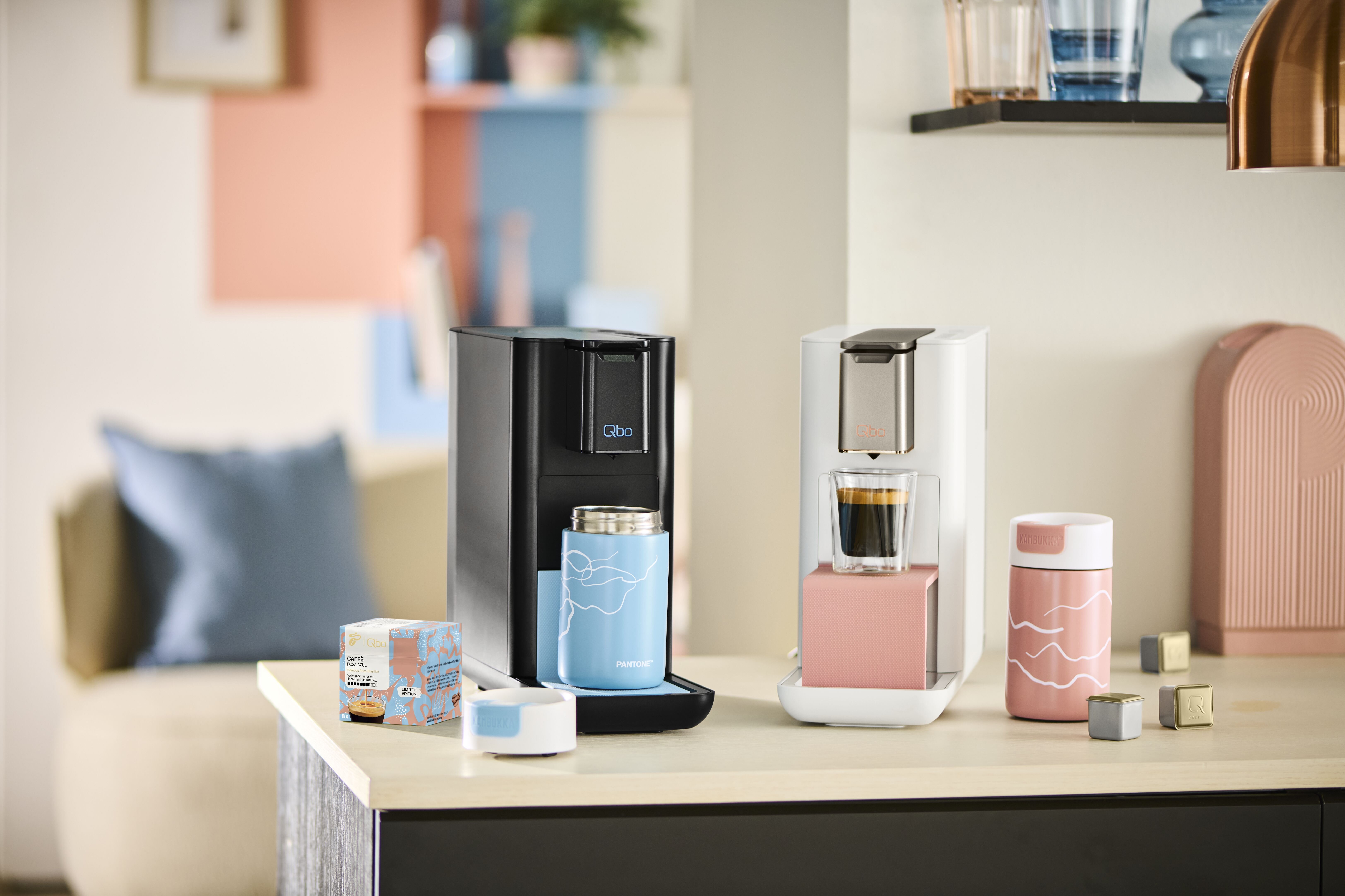 Zwei Kapsel-Kaffeemaschinen mit Bechern auf Theke