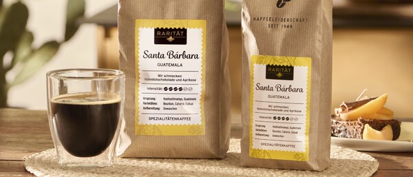 Kaffeetasse neben zwei Beuteln Santa Bárbara Kaffee