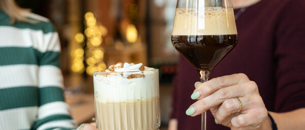 Zwei Frauen halten festliche Kaffeedrinks