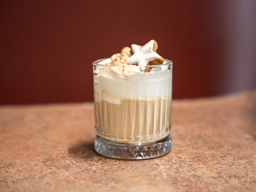 Glas Latte mit Sahne und Zimtsternkeksen