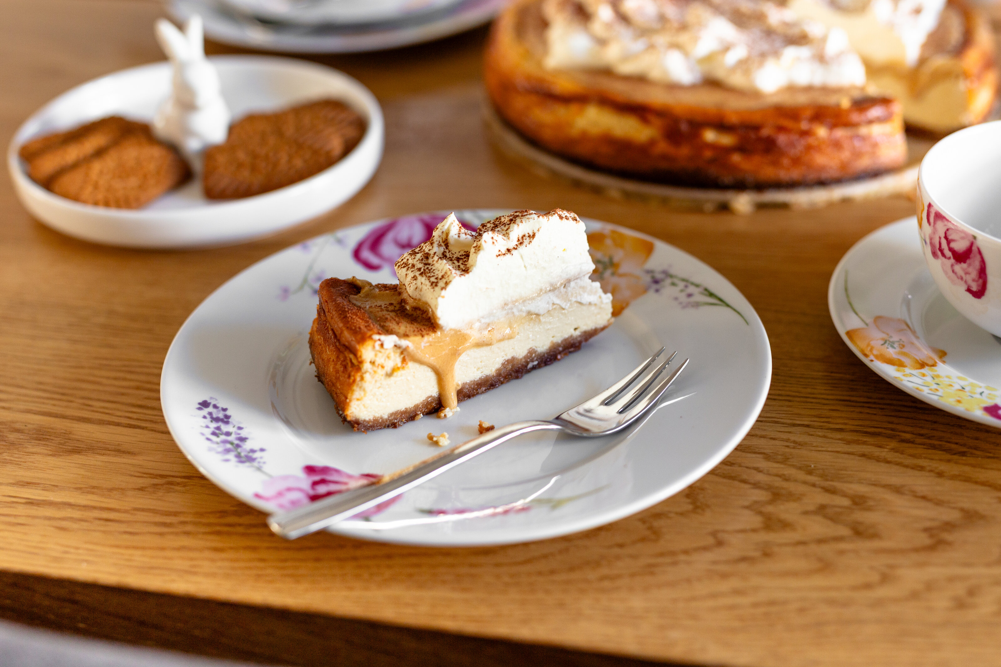 Kuchenstück mit Sahne auf floralem Teller