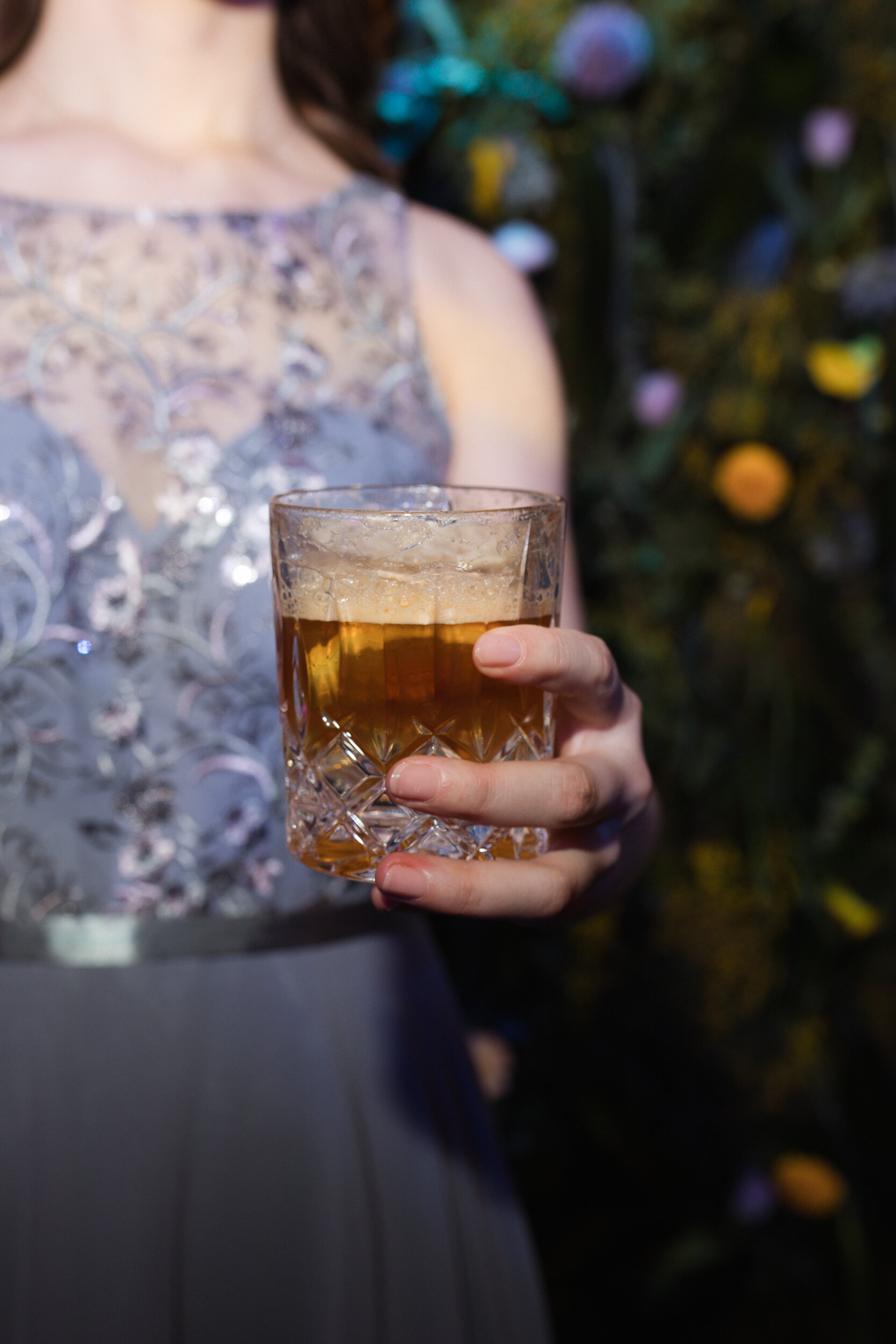 Hand hält Kristallglas mit schaumigem Getränk