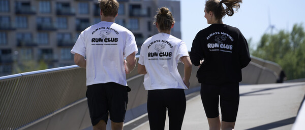 Drei Läufer mit Run-Club-Shirts auf Brücke