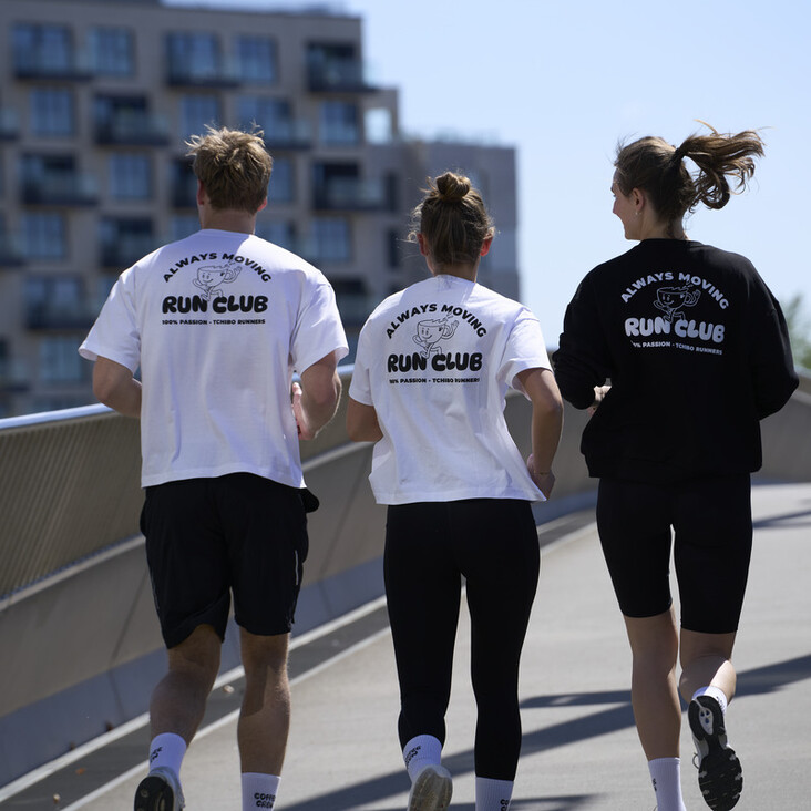 Drei Läufer mit Run-Club-Shirts auf Brücke