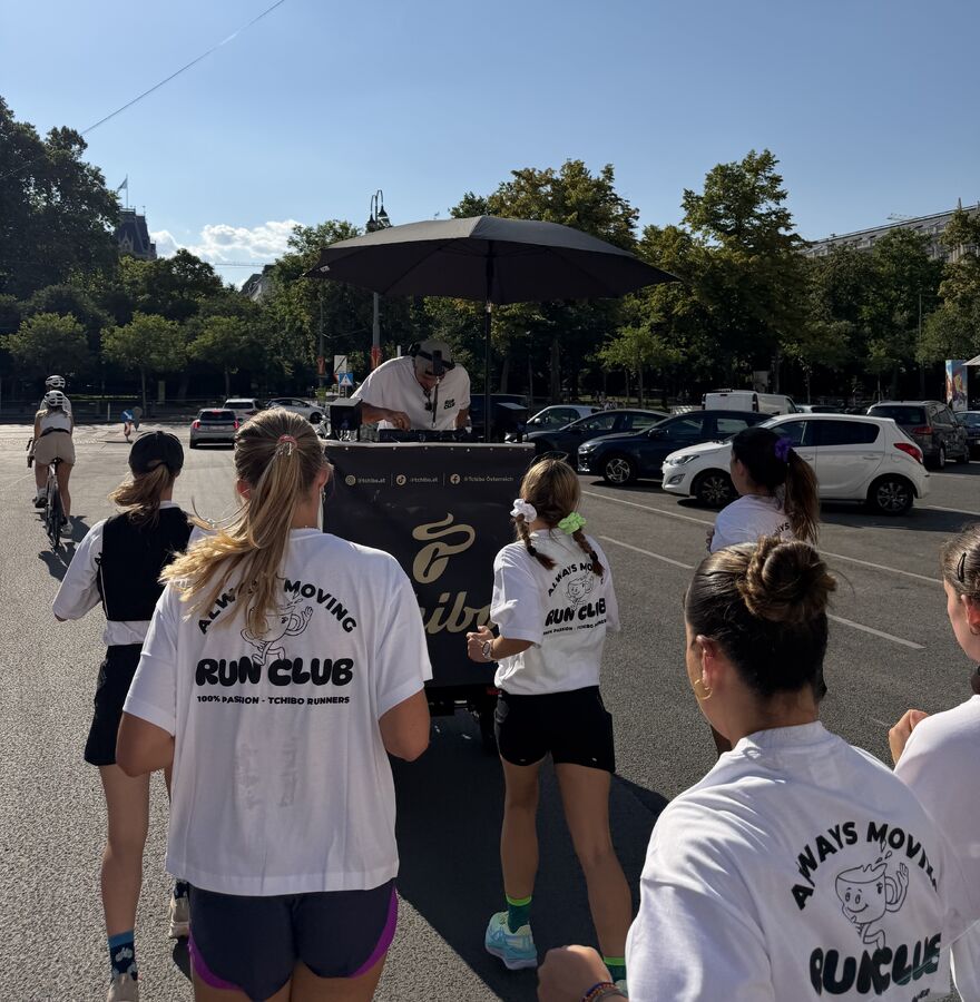 Läufergruppe mit „Run Club“ Shirts auf Straße
