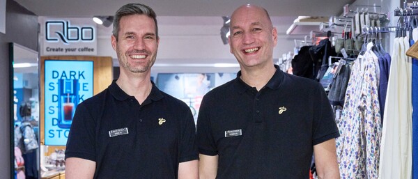 Zwei Verkäufer in schwarzer Uniform im Laden