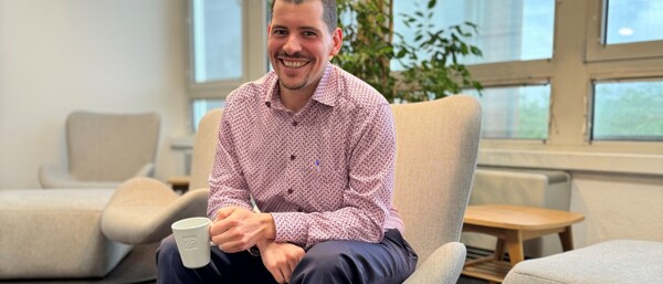 Person mit Kaffeetasse in heller Lounge