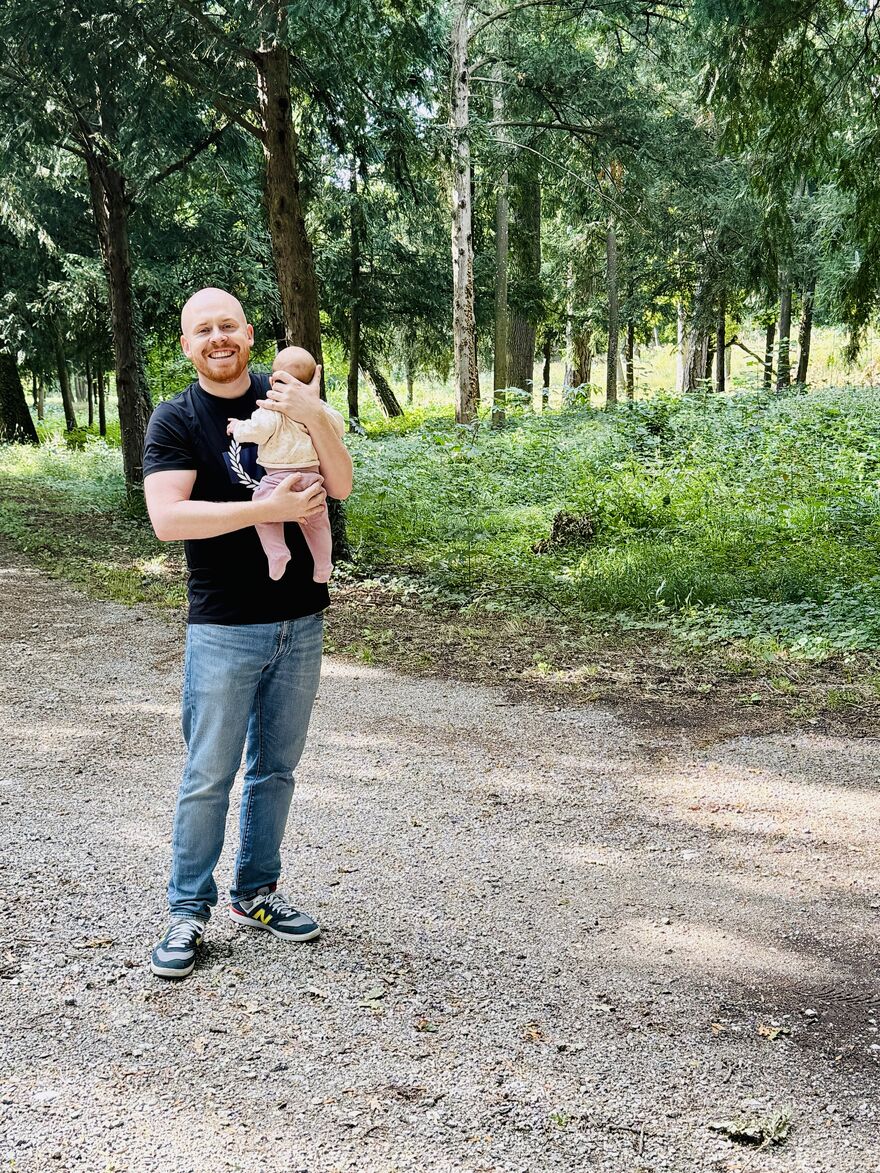 Erwachsener hält Baby auf Waldweg