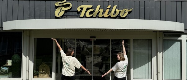 Zwei Frauen posieren fröhlich vor Tchibo-Gebäude