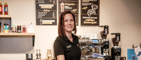 Barista reicht Espresso an Cafétheke