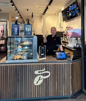 Link: Großansicht des Bildes - Bildinhalt: Lächelnde Barista zeigt Daumen hoch im Café