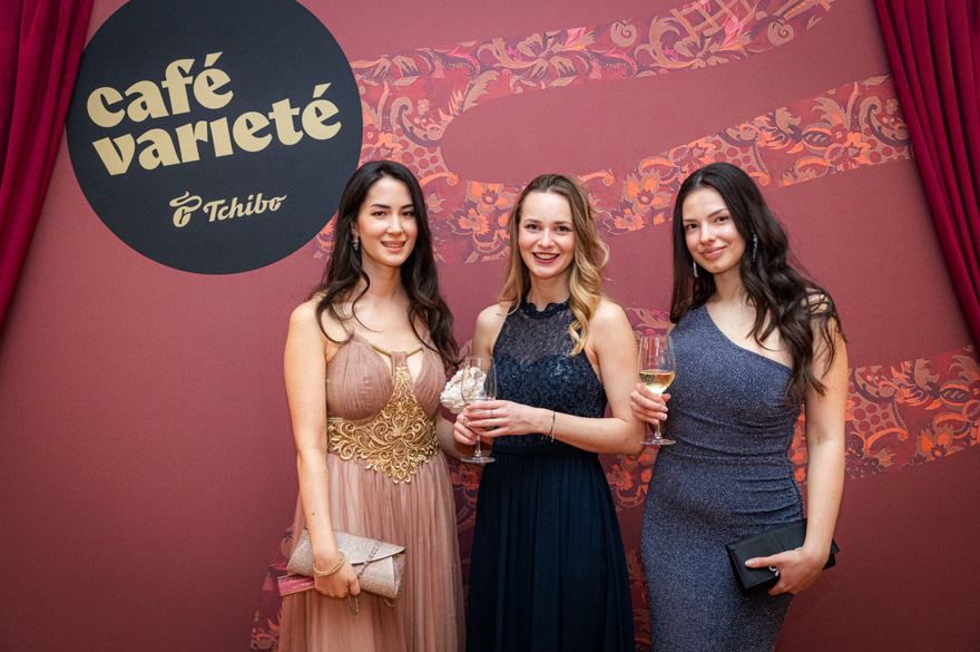 Drei elegant gekleidete Frauen mit Sektgläsern