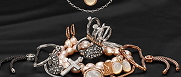 Gold- und Silberschmuck mit Perlen auf schwarzem Stoff
