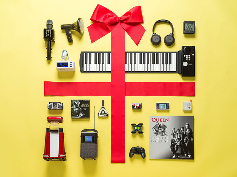 Gelbes Geschenk mit Technik- und Musikgadgets