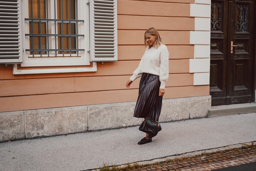 Frau im Herbstoutfit vor apricotfarbener Hauswand