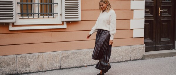 Frau im Herbstoutfit vor apricotfarbener Hauswand
