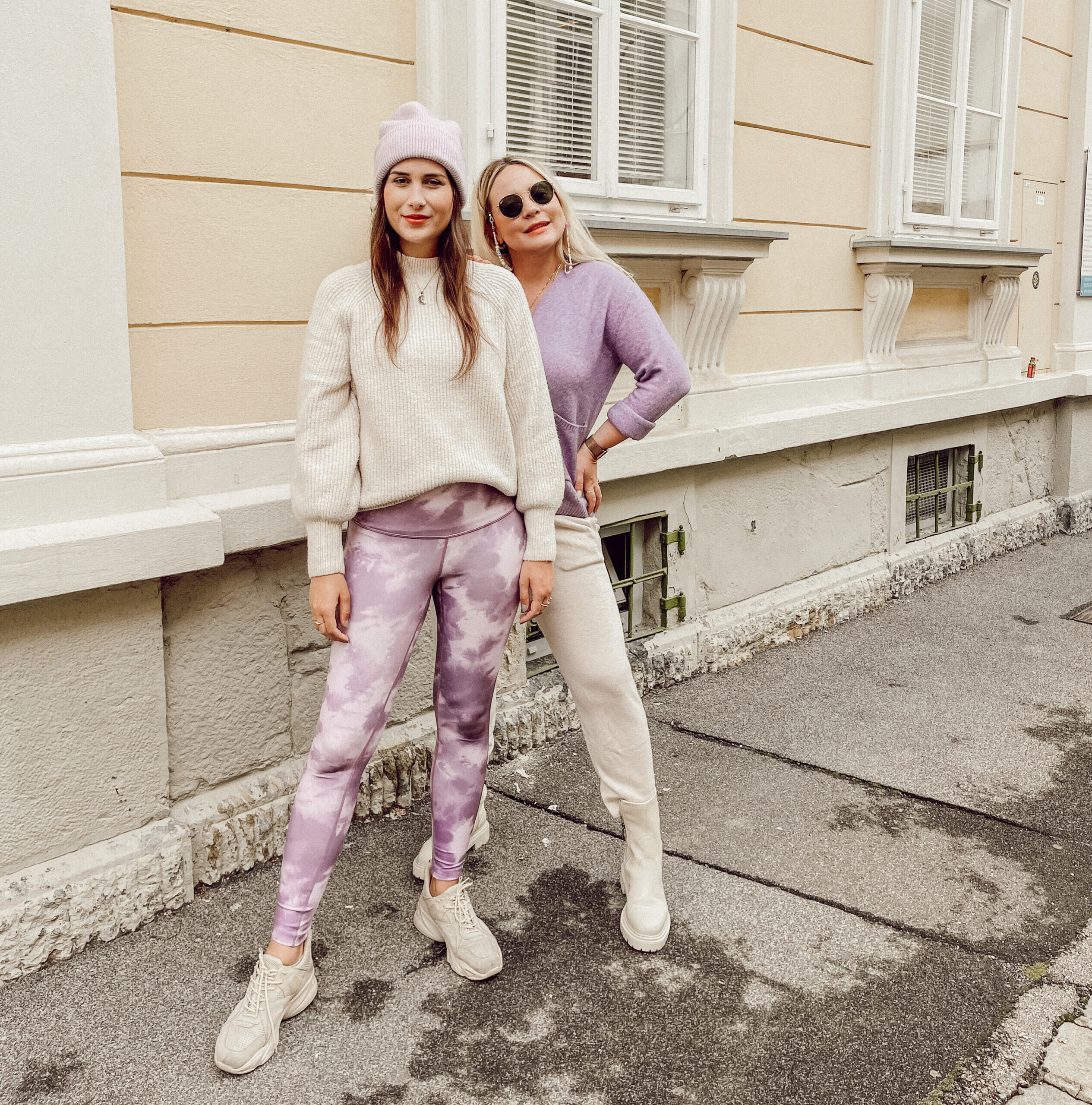 Zwei Frauen in Pastell-Outfits vor Hausfassade