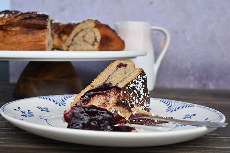 Kuchenstück mit roter Marmelade auf Teller