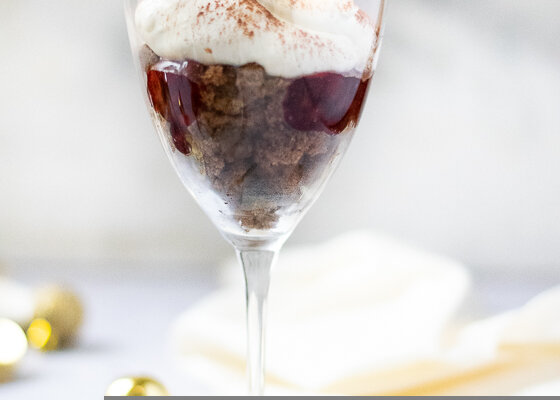 Dessert im Weinglas mit Kirschen und Sahne
