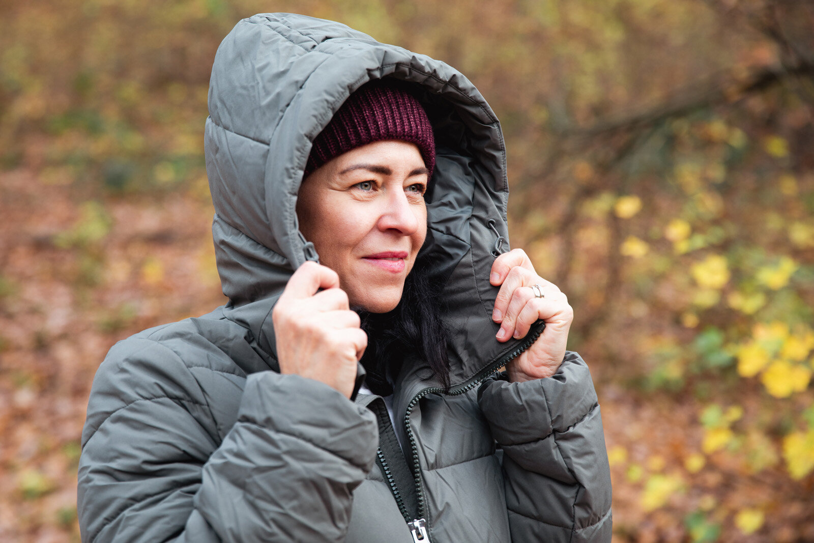 Person mit Kapuzenjacke im herbstlichen Wald
