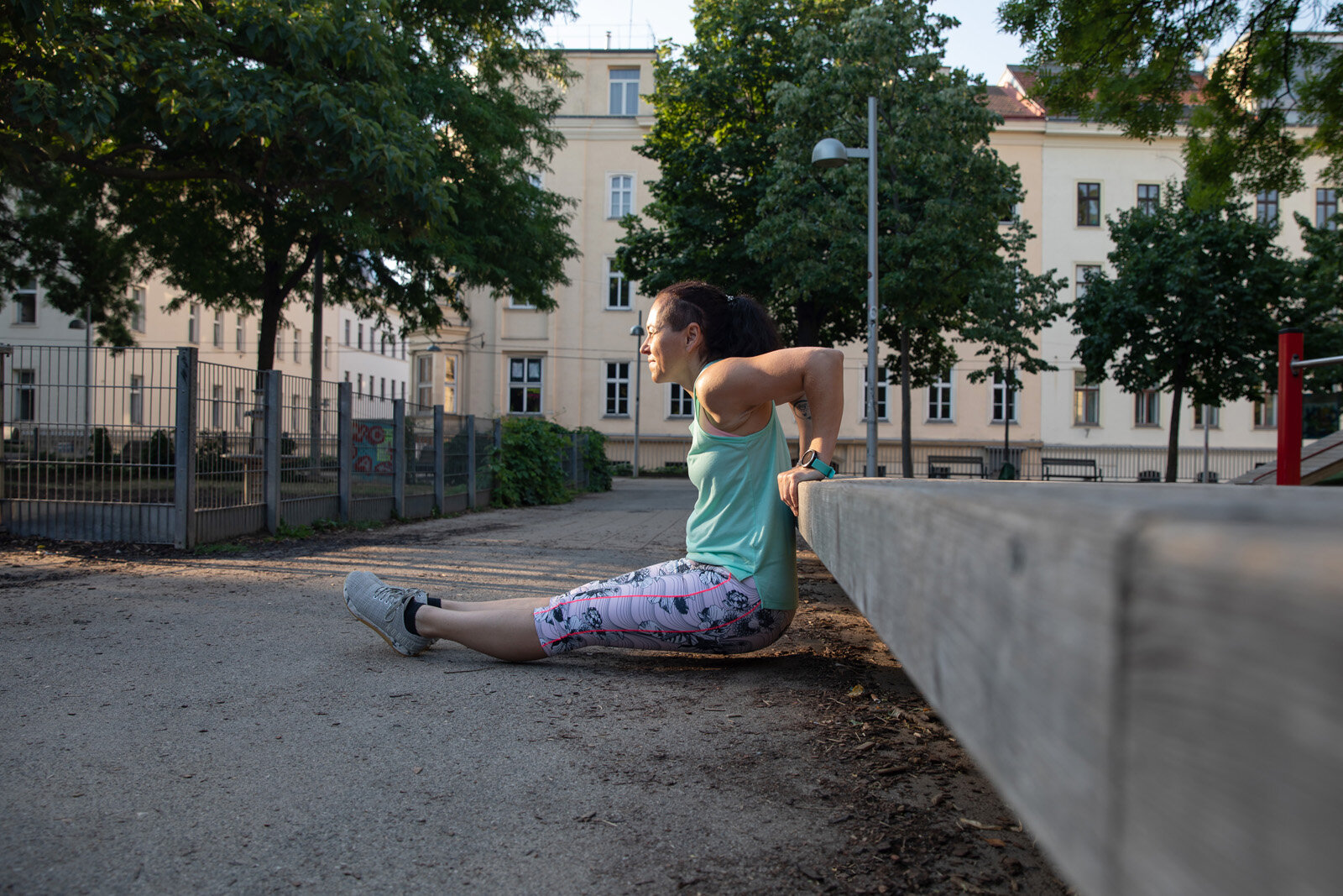 Frau macht Trizepsdips an Bank im Park