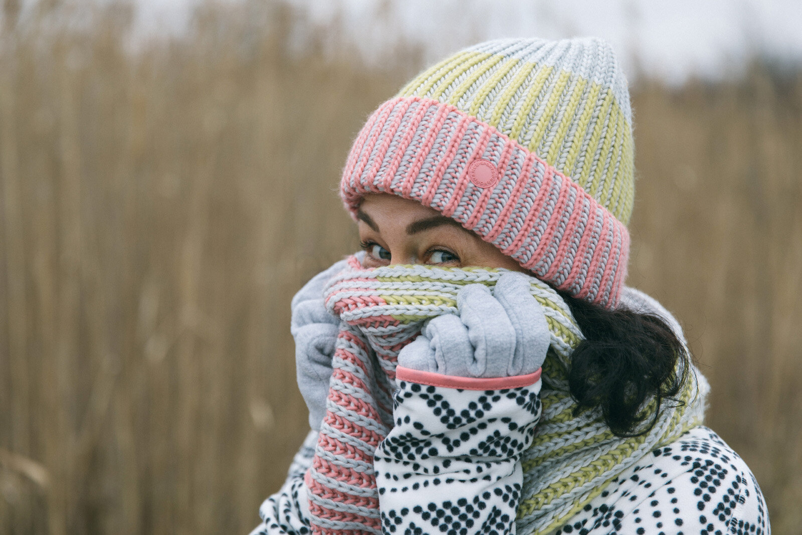 Kind mit bunter Wintermütze und Schal im Freien