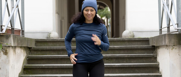Joggerin läuft eine Steintreppe hinunter