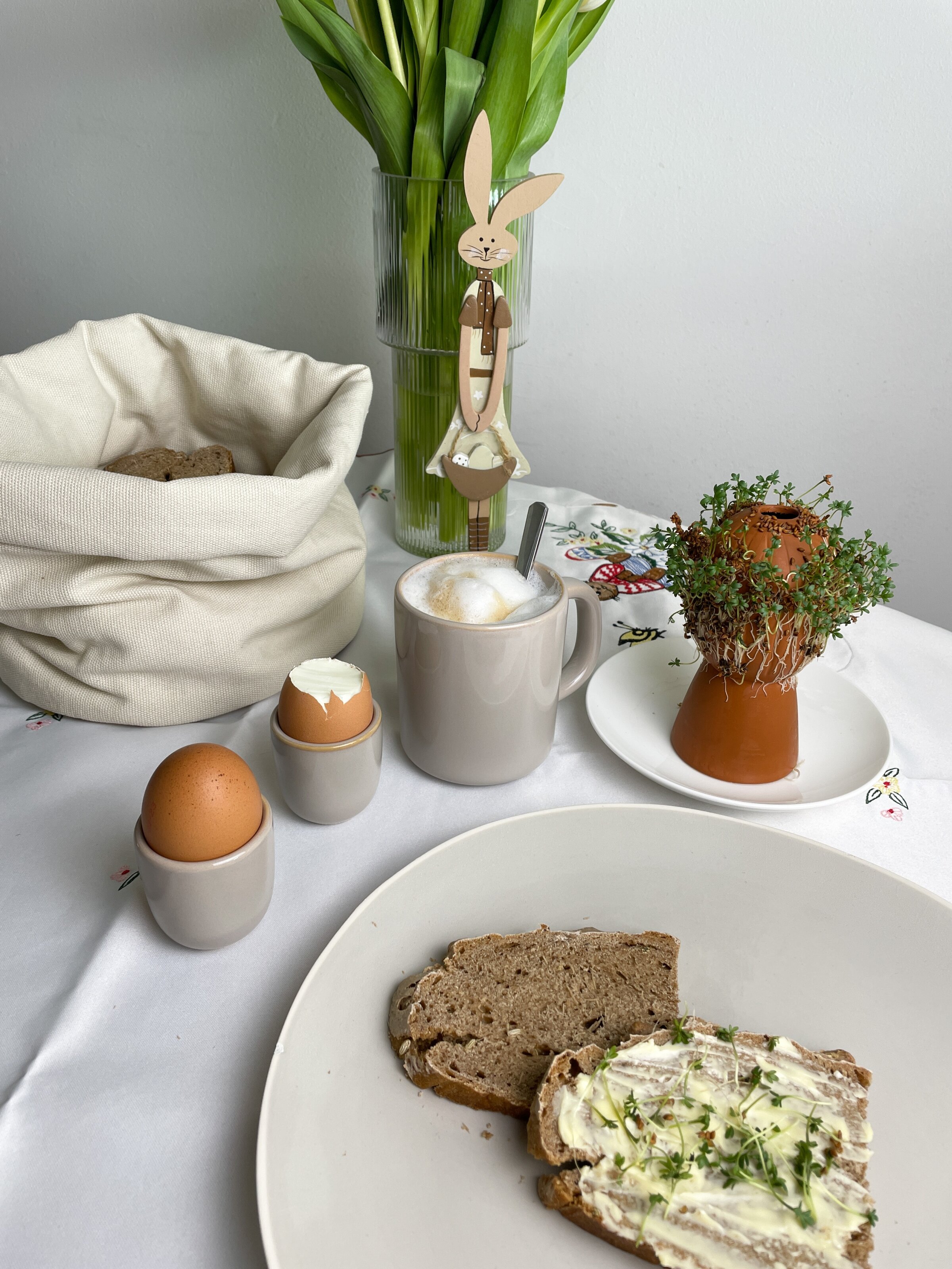 Osterfrühstück mit Brot, Eiern und Kresse