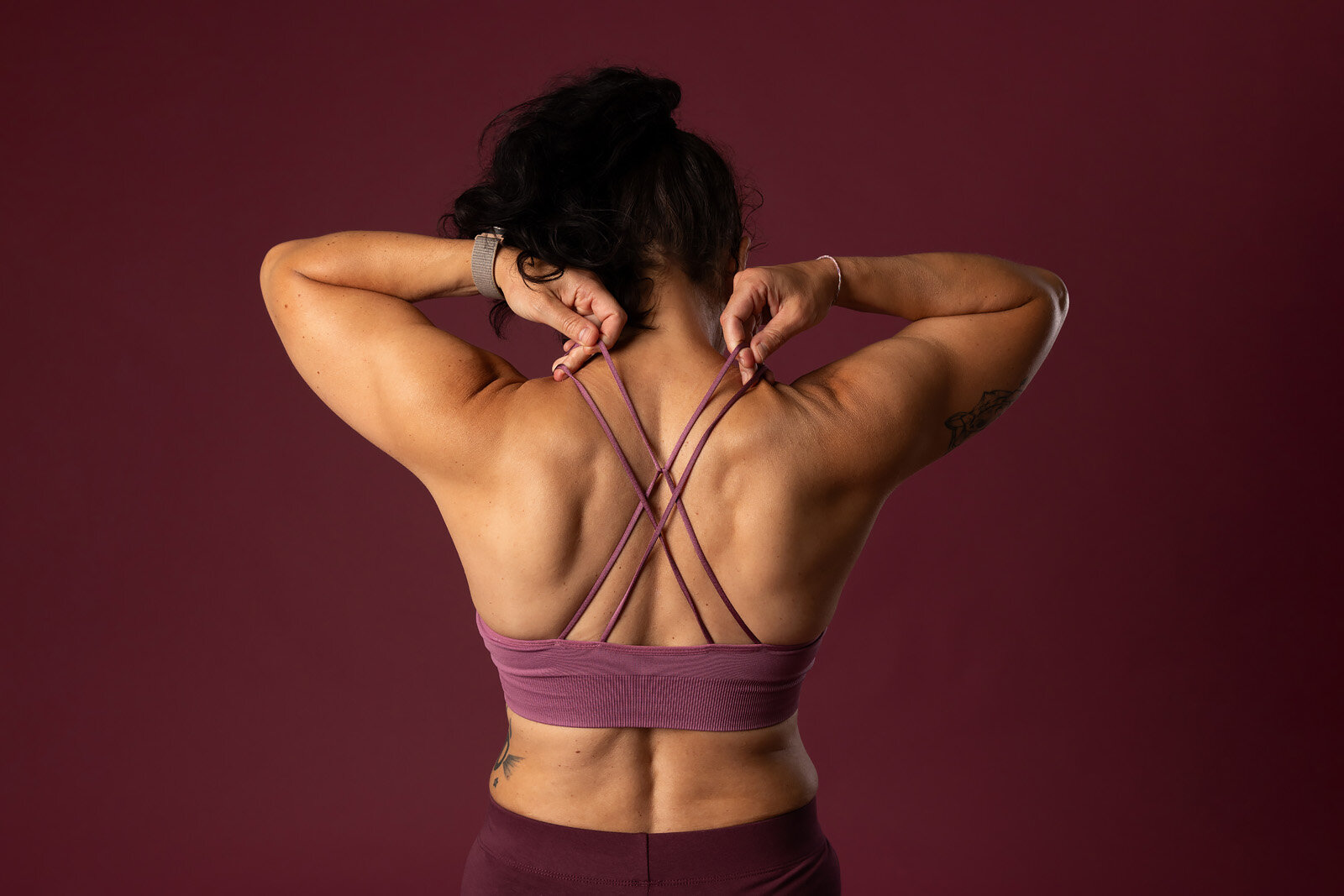Sportliche Frau von hinten in lila Sport-BH
