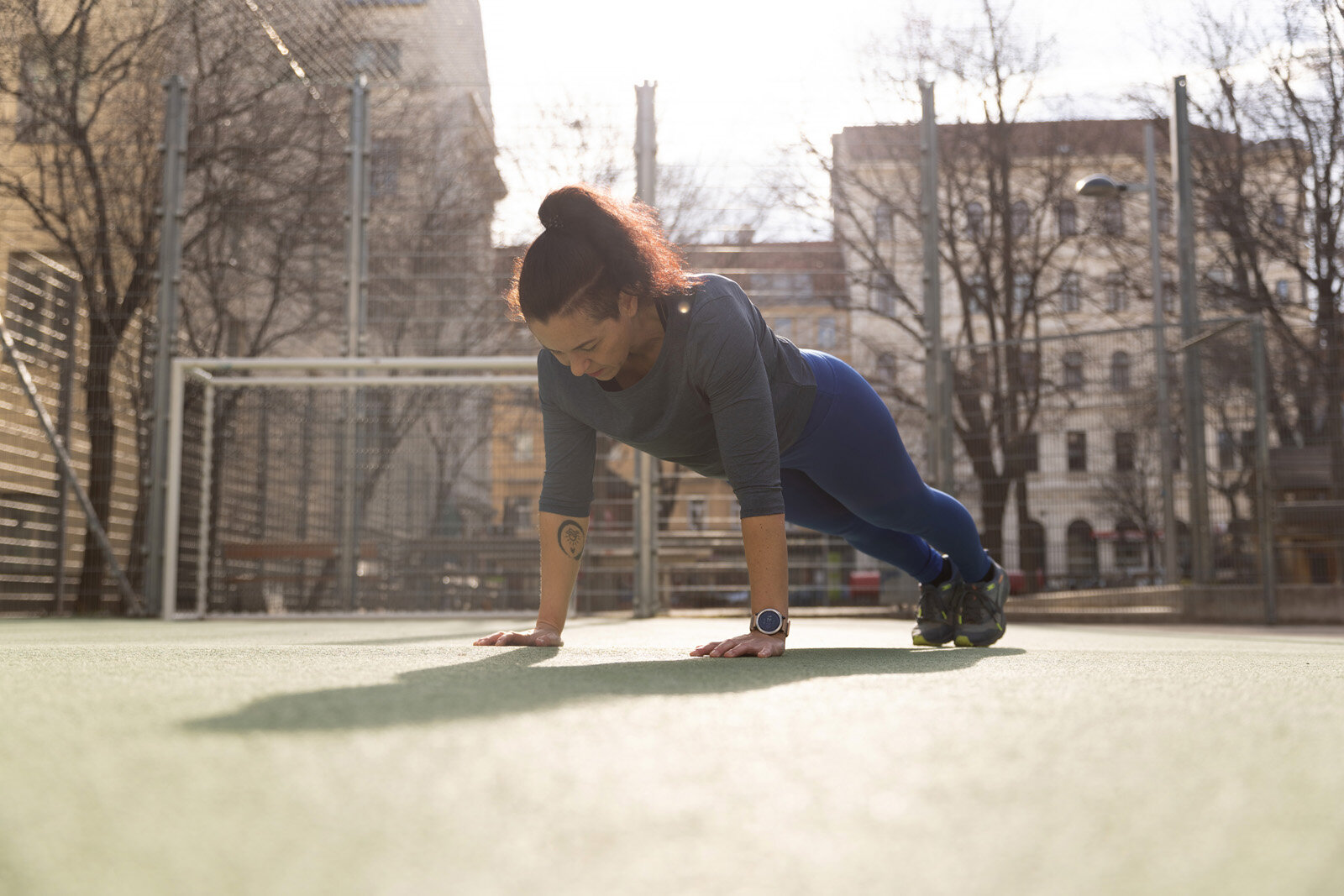 Person macht Plank-Übung auf Sportplatz