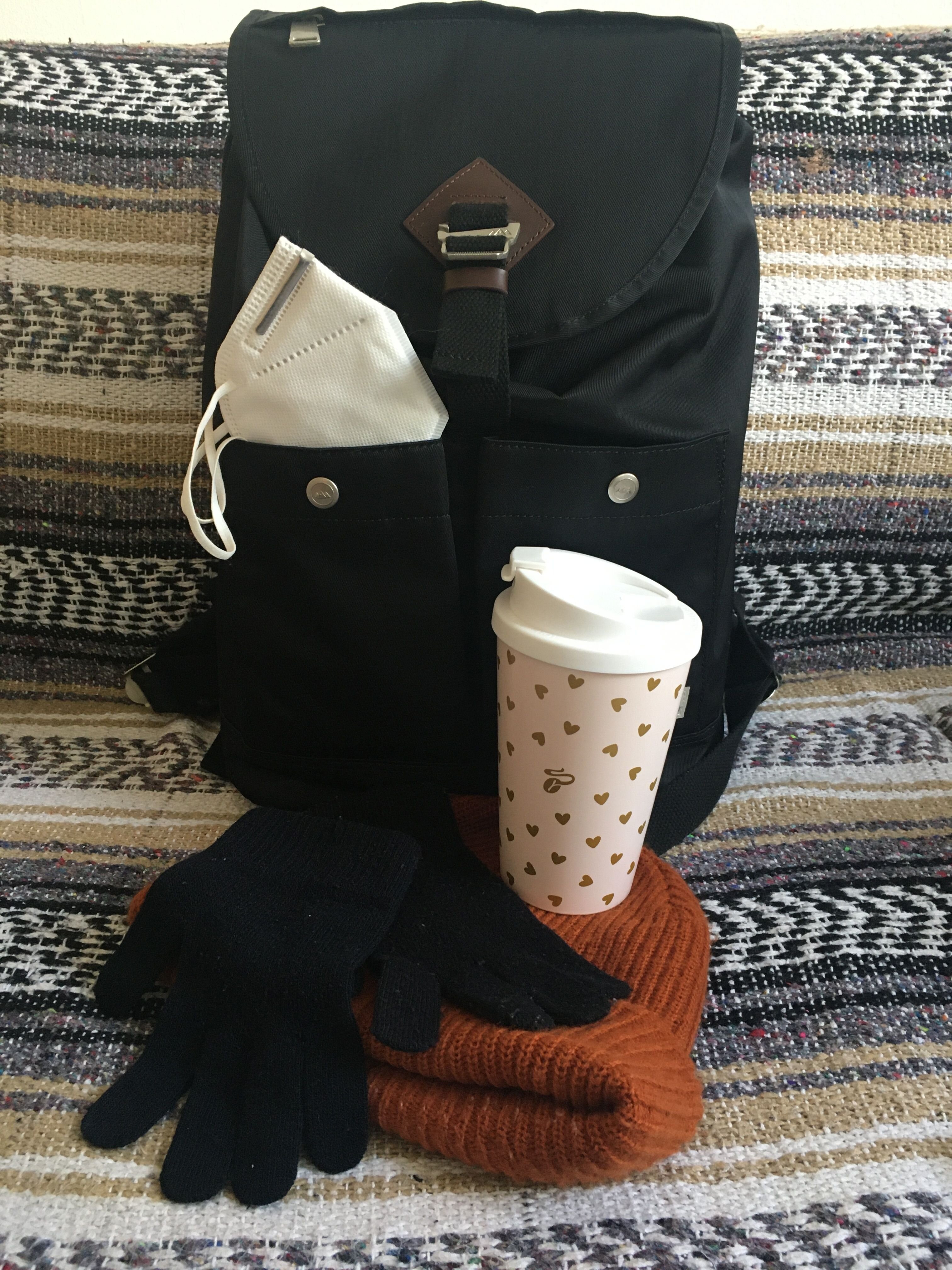 Rucksack mit Maske, Becher, Handschuhen und Schal