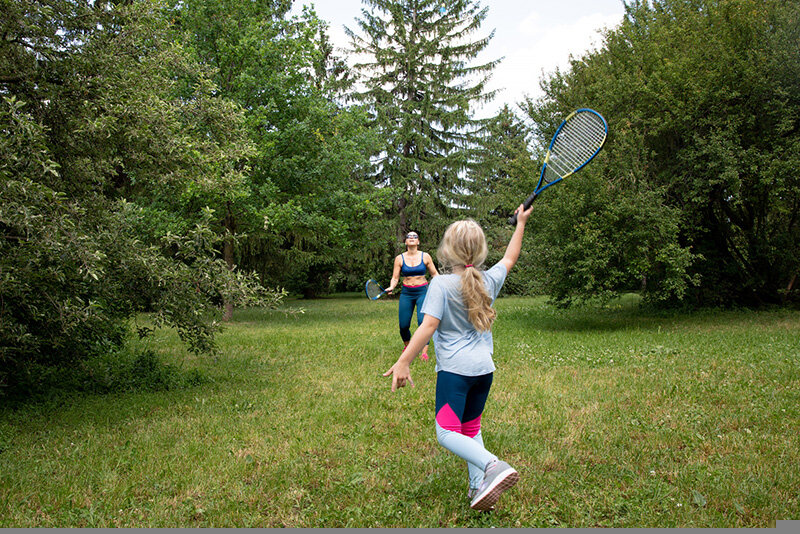 Mutter und Tochter spielen Tennis im Park