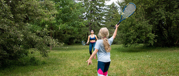 Mutter und Tochter spielen Tennis im Park