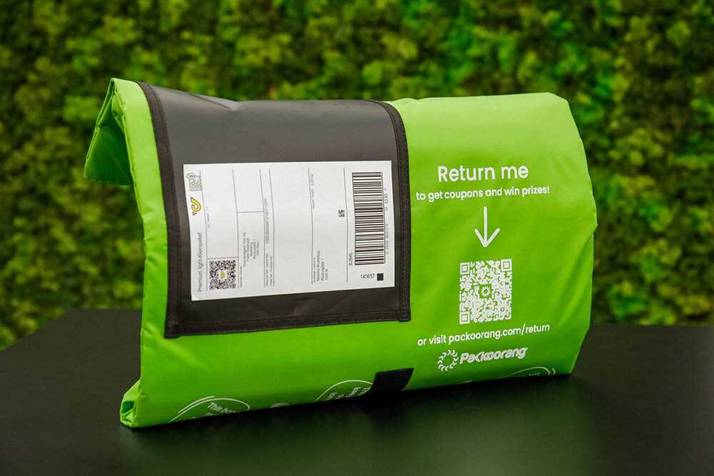 Grüne Rücksendeverpackung mit QR-Code und Label