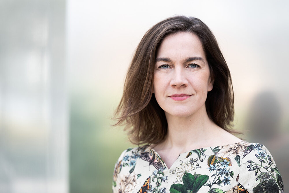 Person mit schulterlangen Haaren, florales Kleid