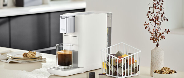 Weiße Kapsel-Kaffeemaschine mit Glas Espresso
