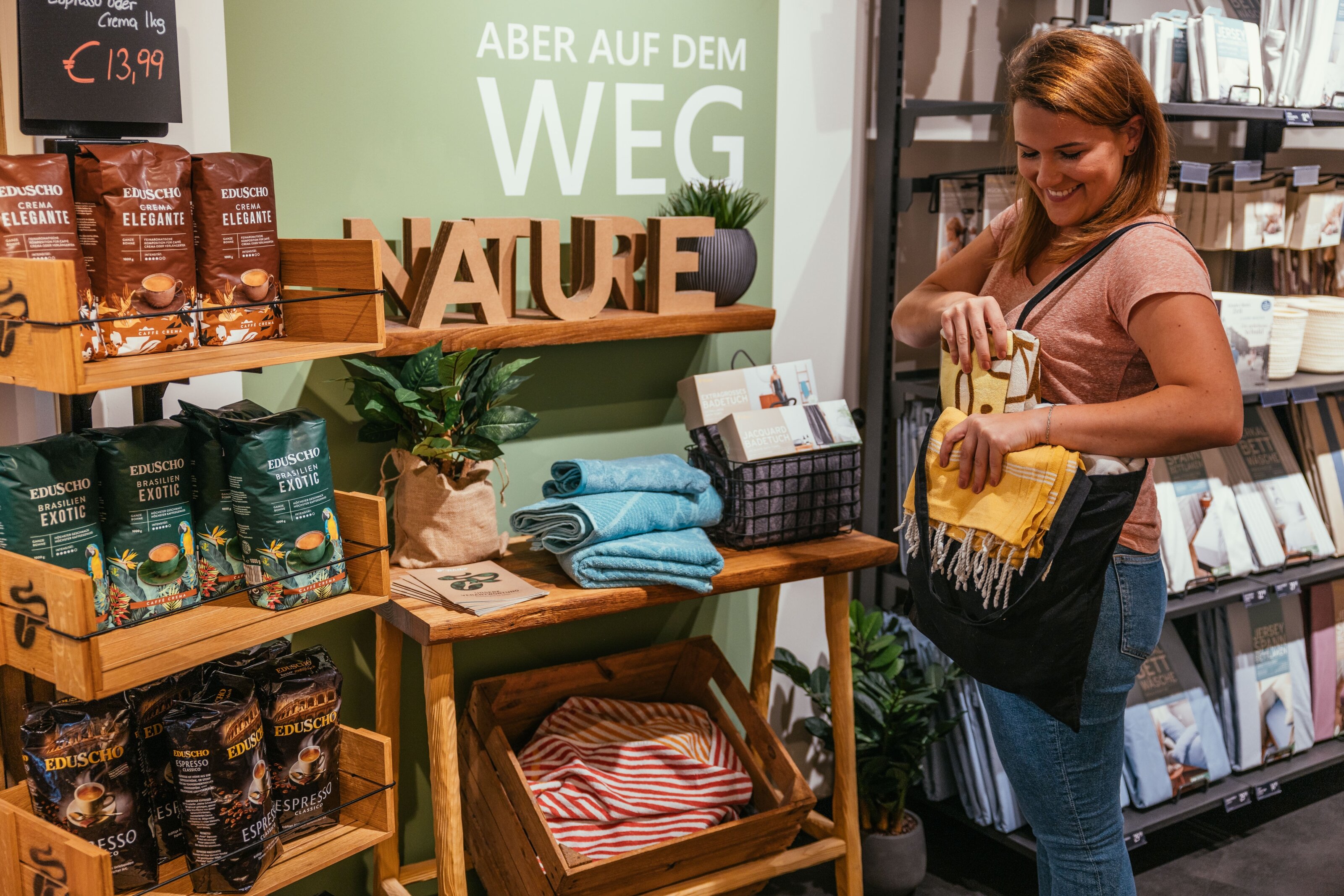 Frau steckt gelbes Tuch in Tasche im Laden