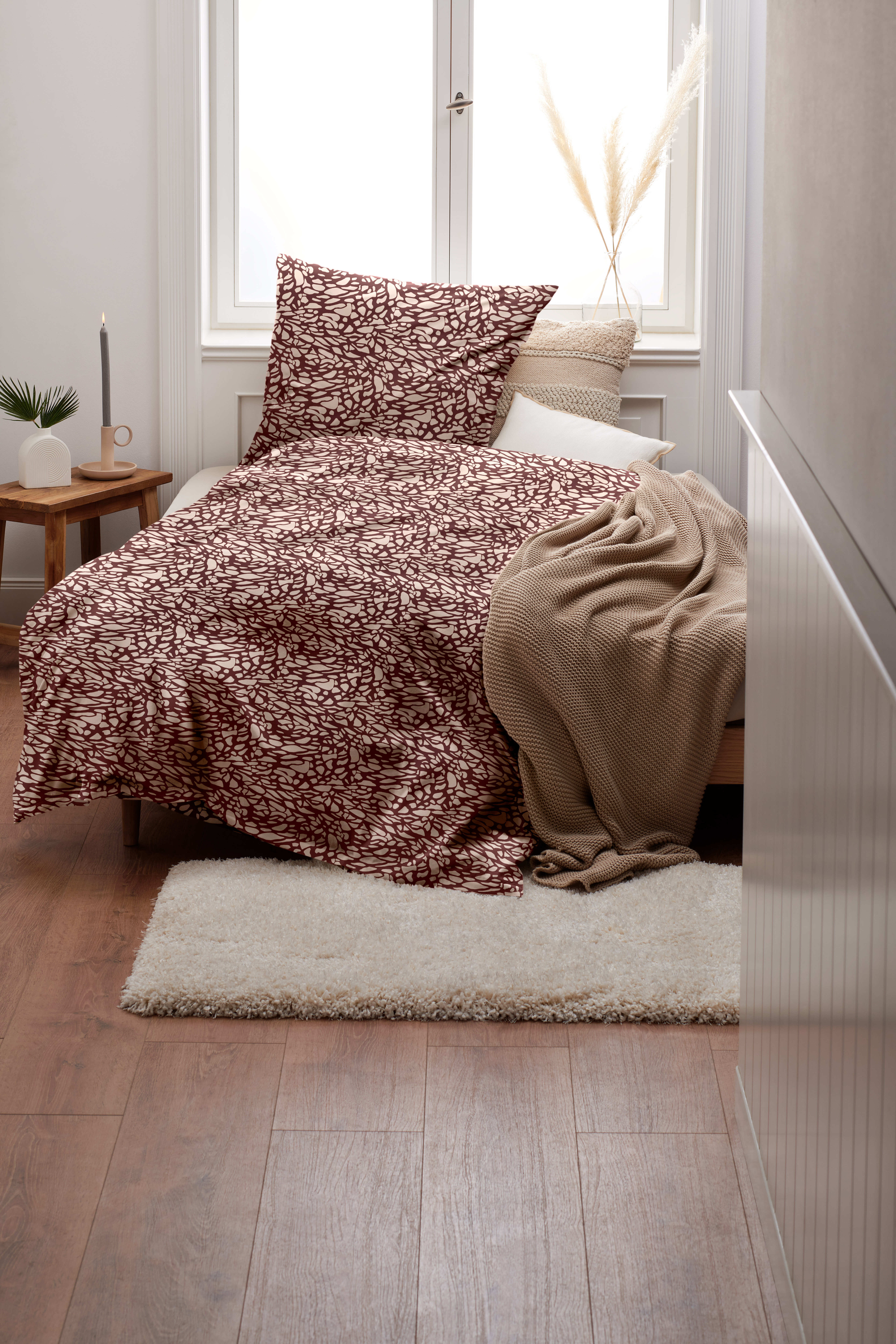 Gemütliches Bett mit gemusterter Bettwäsche