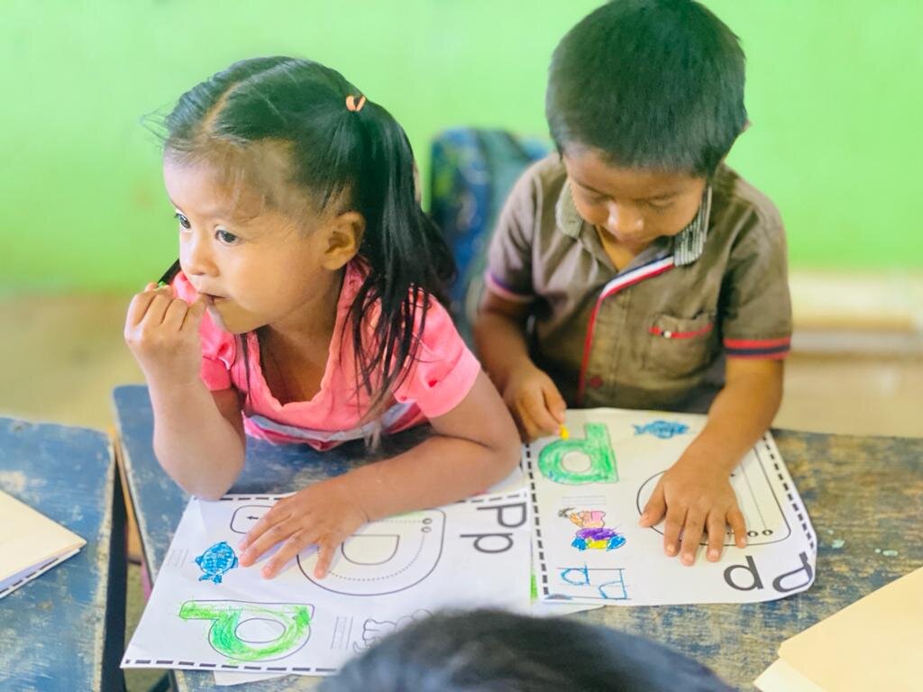 Kinder malen bunte Arbeitsblätter im Klassenzimmer