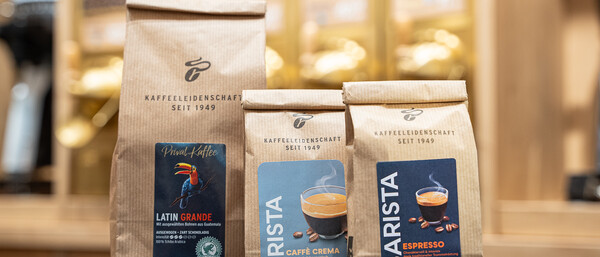 Drei Kaffeepackungen aus Papier im Café-Schrank