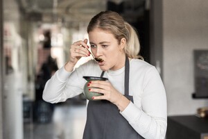 Link: Großansicht des Bildes - Bildinhalt: Frau in Schürze probiert Suppe aus Schale