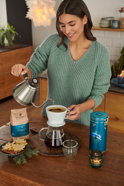 Frau brüht Filterkaffee in gemütlicher Küche