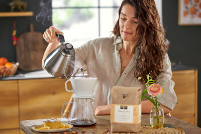 Person brüht Handfilterkaffee in gemütlicher Küche