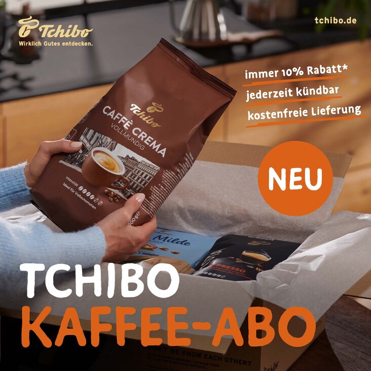 Person packt Tchibo Kaffeepaket aus Karton
