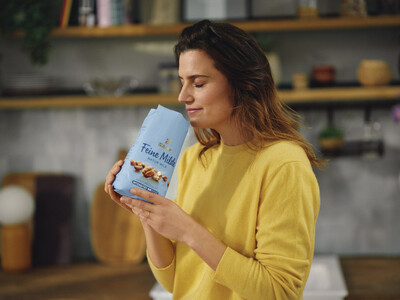 Person in Gelb hält Packung Kaffee 