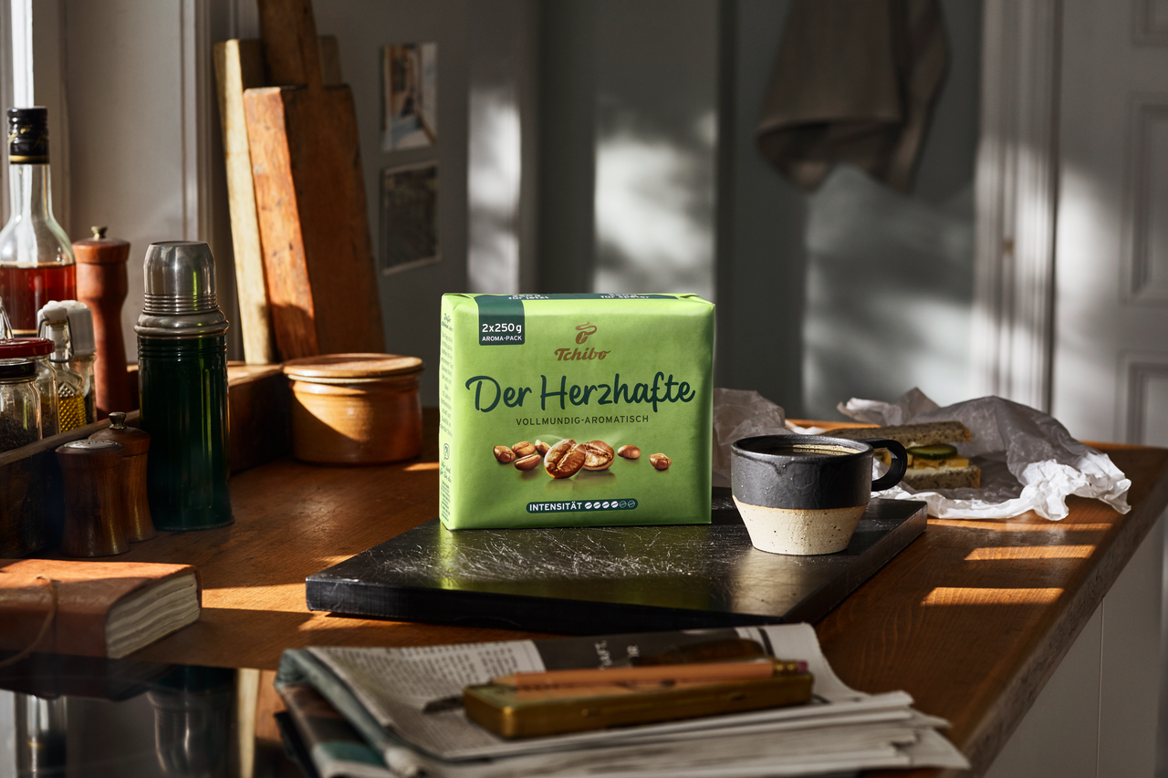 Kaffeepackung „Der Herzhafte“ neben Tasse