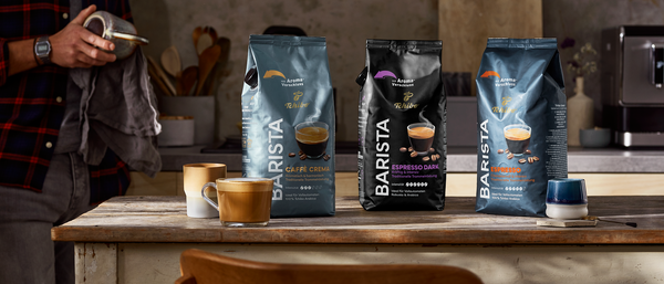 Küchentisch mit drei Tchibo-Barista-Kaffeepackungen