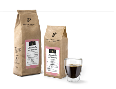 Zwei Kaffeepackungen und ein Glas mit schwarzem Kaffee